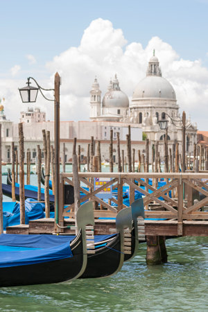Gondolas at The Riva degli Schiavoni, quay Venice, Italy. Basilica di Santa Maria della Salute church in backgroundの写真素材