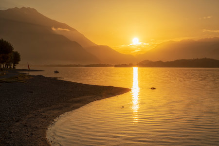 Vibrant sunrise at Domaso beach, Lake Como, looking towards valtellina valleyの写真素材