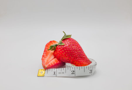 Strawberries with measuring tape on white background. Diet concept.の写真素材
