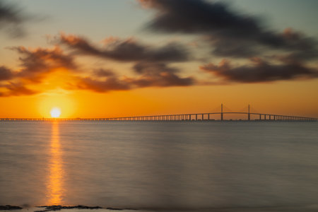 A morning sunrise at the Sunshine Skyway Bridge over Tampa Bay, St Petersburg, Florida September 2024. A beautiful sunrise at the beach in Fort DeSoto Park looking at The Sunshineの写真素材