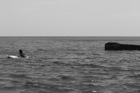 Black and white photo of a man in a boat on the seaの写真素材