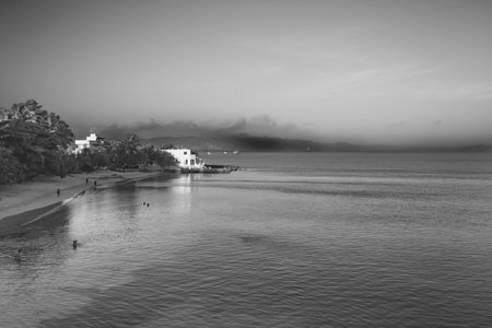 The beachfront from a cliff oview verlooks a vast shoreline with mountains and a beachfront with brilliant skiesの写真素材