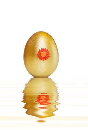 Golden Easter treasure egg with water reflections over white. の写真素材