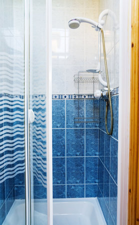 Modern shower cabin with glass doors in blue and whiteの写真素材