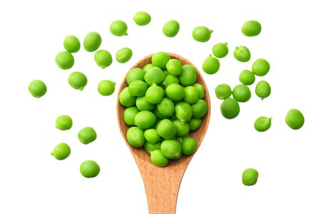 fresh green peas in a wooden spoon isolated on a white background. top viewの写真素材