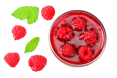 ripe raspberries with green leaves and jam isolated on white background. top view
