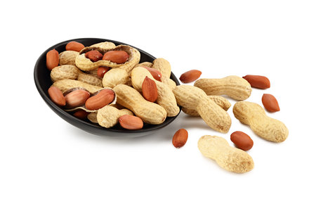 Dried peanuts in a black plate isolated on white background. Food
