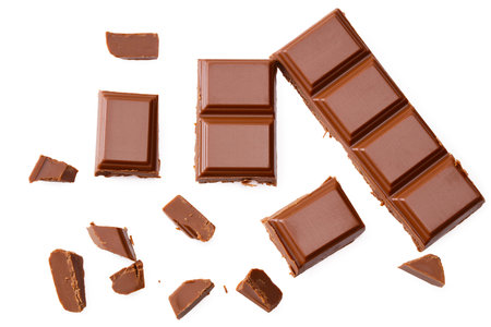 Milk chocolate pieces isolated on white background. top view