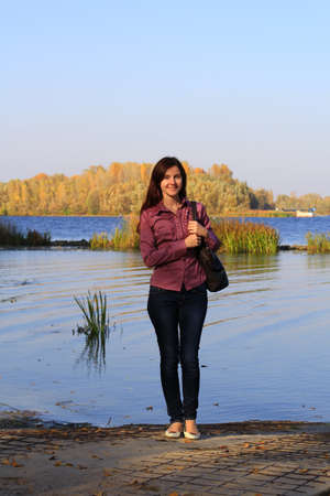 young slim woman by the river in autumnの写真素材