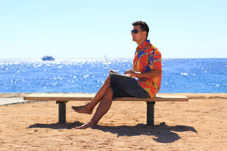 man freelancer working on his laptop at the seaの写真素材