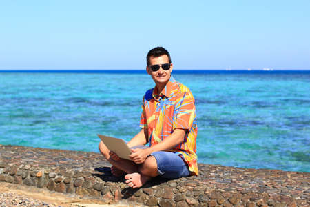 man freelancer working on his laptop at the seaの写真素材