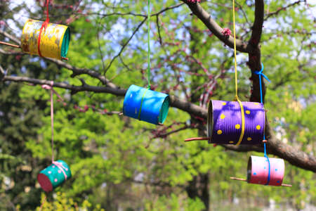 colorful bird feeders made of cans and tinsの写真素材