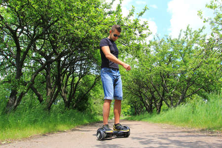 young man riding electrical scooter - hoverboard, gyro scooter, smart balance wheelの写真素材