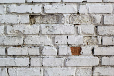 white brick wall with uneven and missing stones for backgroundの写真素材