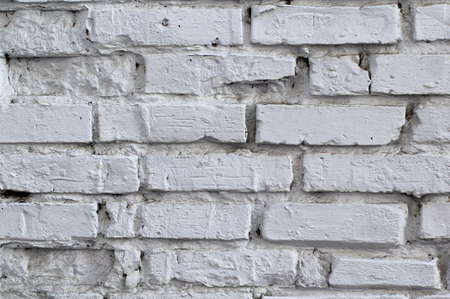 white brick wall with uneven and missing stones for backgroundの写真素材