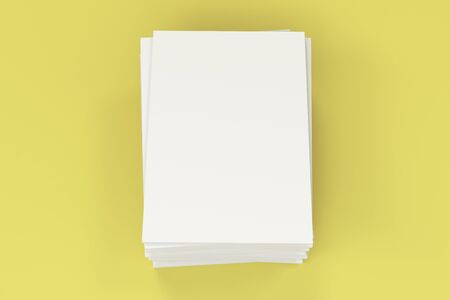 Stack of blank white closed brochure mock-up on yellow background. Magazine cover template. 3D rendering illustrationの写真素材