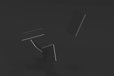 Four blank notebooks with black covers and metal spiral bound on black background. Business or education mockup. 3D rendering illustrationの写真素材