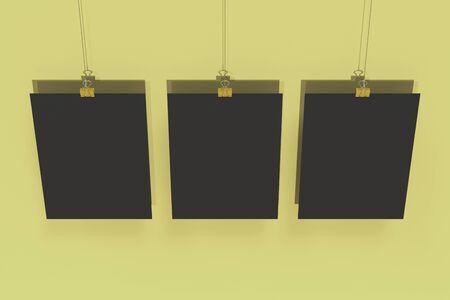 Three blank black posters with binder clip mockup on yellow background. Poster or paper sheet template. 3D rendering illustrationの写真素材
