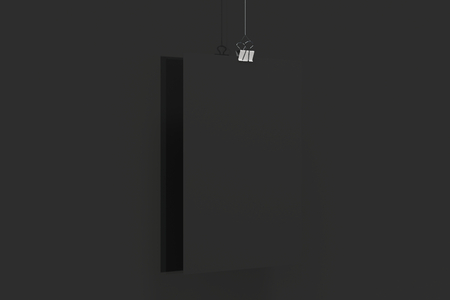 Blank black poster with binder clip mockup on black background. Poster or paper sheet template. 3D rendering illustrationの写真素材
