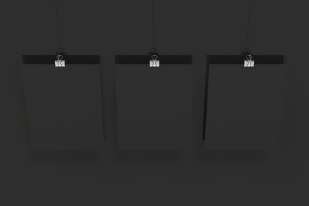 Three blank black posters with binder clip mockup on black background. Poster or paper sheet template. 3D rendering illustrationの写真素材