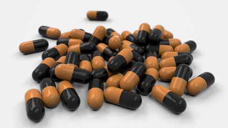 Pile of black and orange medicine capsules on white background. Medical, healthcare or pharmacy...