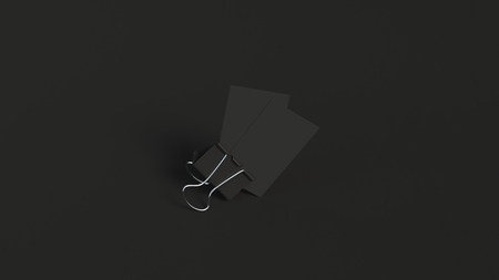 Two black business cards in paper clip on black background. Branding mockup. 3D rendering illustration.の写真素材