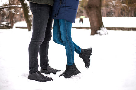 Happy couple have fun in winter park. They are walking and playing with each other. Concept of...