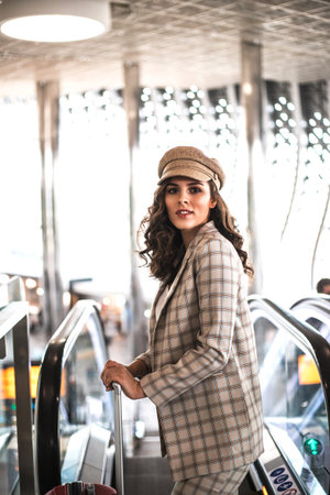 Beautiful business woman on escalator in airport. Job and travel concept