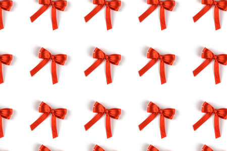 Pattern of red silk gift bows isolated on white background. Festive concept.の写真素材