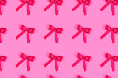 Pink silk gift bow isolated on pink background. Festive concept.の写真素材