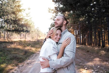 Beautiful young couple in love hugging in the autumn forest.の写真素材