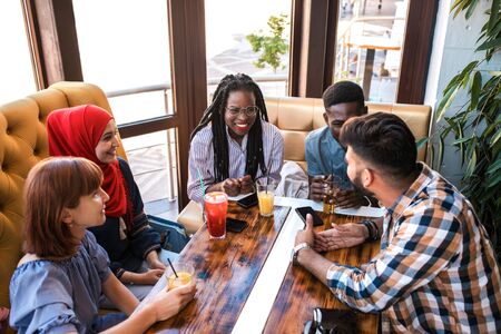 Group of happy friends drinking juice and lemonade at cafe. Friendship, youth and food concept.の写真素材