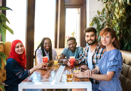 Group of happy friends drinking juice and lemonade at cafe. Friendship, youth and food concept.の写真素材