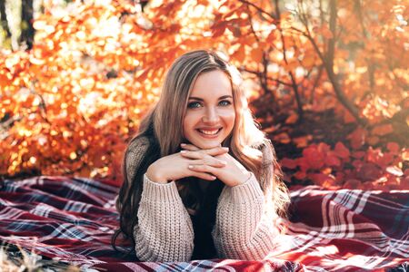 Beautiful smiling woman enjoying autumn in the forest.の写真素材