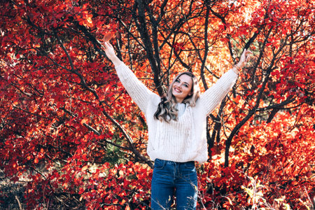 Beautiful smiling woman enjoying autumn in the forest.