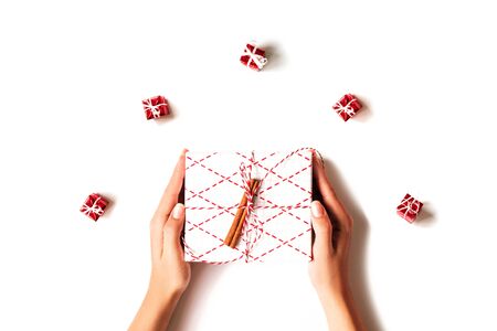 Womans hands holding gift box isolated on white background with little gift boxes and skein of yarn. Flat lay style.の写真素材