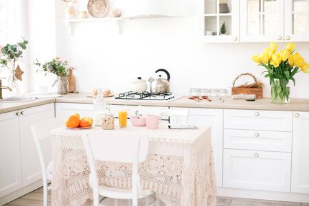 Interior of modern white kitchen with fresh spring flowers.の写真素材