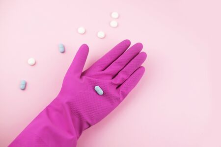 Woman hand in protective gloves with pills. Medicine for coronavirus treatment.の写真素材