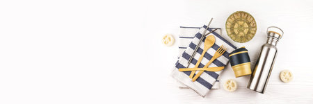 Banner made from set with bamboo cutlery, reusable coffee mug and water bottle with kitchen towels on white background. Sustainable lifestyle. Zero waste and plastic free concept.の写真素材