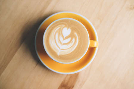 Fresh flavored coffee art is on the wooden table.の写真素材