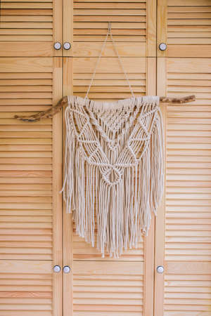 Macrame wall hanging decoration on wooden background.の写真素材