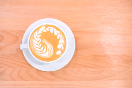 Fresh flavored coffee art is on the wooden table.の写真素材
