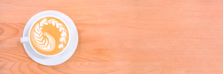 Banner with fresh flavored coffee art is on the wooden table.