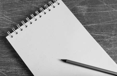 View from above of empty blank notebook on gray background with pencil on it.の写真素材