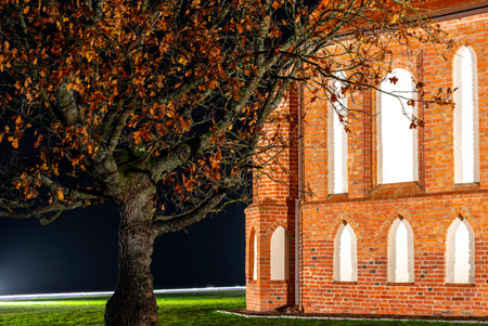 Fragment of ancient red brick building with white empty windows at the night.の写真素材