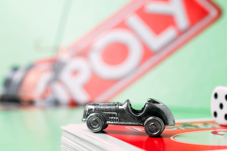 Monopoly car, monopoly board and dices on the monopoly chance cards.
