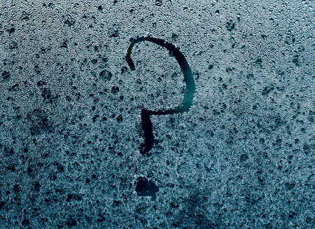 Close up of question sign handwritten on wet glass.の写真素材