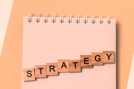 Top view of message strategy with wooden letters on notebook in yellow.の写真素材