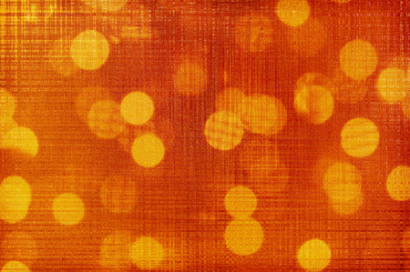 Abstract festive orange background with blurred light bulbs.