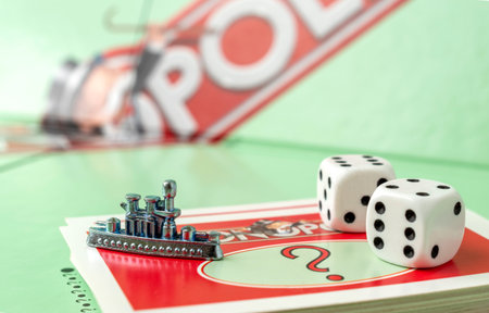 Kaunas, Lithuania - July 2022: monopoly ship token, monopoly board and dices on the monopoly chance cards.のeditorial素材